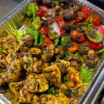 chicken and vegetables skewers in a catering foil tray