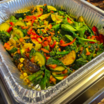 catering foil container with sautéed vegetables
