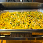 Catering foil tray in rechaud pasta with chicken mushrooms and asparagus
