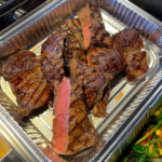 catering foil container with pieces of grilled pub steak
