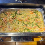 Catering foil tray in rechaud with pasta with seafood
